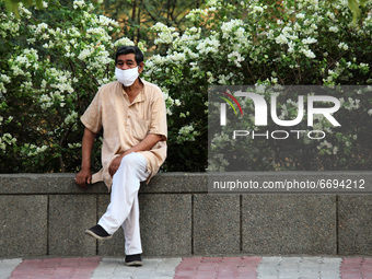 A man wearing a face mask sits along a street, amidst the spread of coronavirus cases, in New Delhi, India on May 8, 2021. India recorded ov...