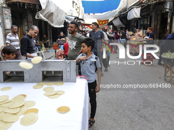 A Palestinian makes traditional sweets known as ,Qatayef, a dessert typically for the holy month of Ramadan, at a market in Gaza City, on Ma...
