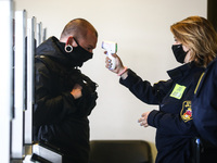 A personnel is measuring body temperature on the first day of the opening of the new Covid-19 Vaccination point at Tauron Arena Krakow. Krak...