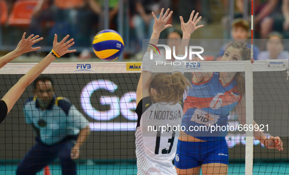 Malesevic Tijana (R) of Serbia spikes the ball over Nootsara Tomkom (#13) of Thailand during their FIVB World Grand Prix intercontinental ro...