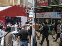 People walk pass a booth for the June 4 Vigil in Hong Kong, Sunday, May 9, 2021. The Hong Kong Alliance in Support of Patriotic Democratic M...