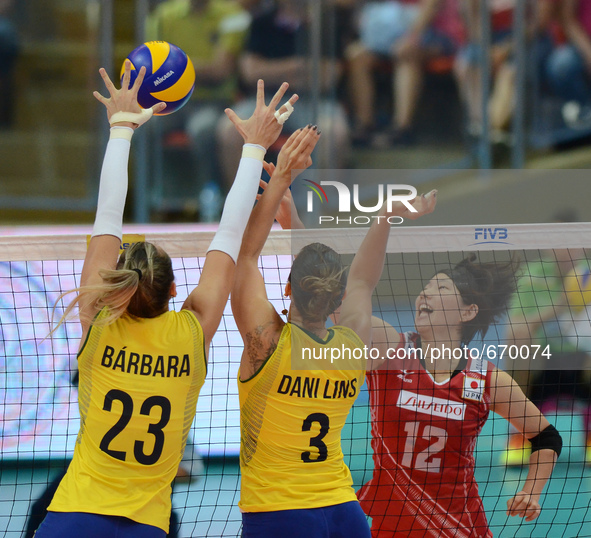 Yuki Ishii (R) of Japan spikes the ball over Brazil players during their FIVB World Grand Prix intercontinental round match at Indoor Stadiu...