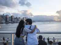 A Couple kiss while looking at the sunset in Hong Kong, Monday, May 10, 2021. (