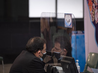An unidentified man wearing a protective face mask speaks on his smartphone while attending the election Headquarter in the Iranian Interior...