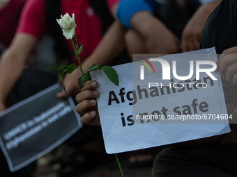 Refugees members of the Shiite Hazara community carries a placards to show solidarity with the victims of Kabul school bombing, outside UNHC...