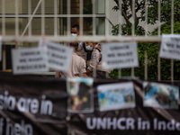 Security guard inside UNHCR during refugees members of the Shiite Hazara community show solidarity with the victims of Kabul school bombing,...