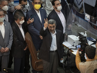 Former president Mahmoud Ahmadinejad (C) flashes a Victory sign while attending the Iranian Interior Ministry building to register as a cand...