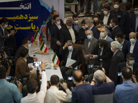 Former president Mahmoud Ahmadinejad (C) gestures while attending the Iranian Interior Ministry building to register as a candidate for June...