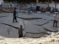 A picture taken early on May 12, 2021 shows a huge crater in main street in Gaza City, following Israeli airstrikes on the Hamas-run territo...