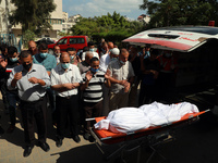 People offer funeral prayers next to the body of a Palestinian, who was killed amid a flare-up of Israeli-Palestinian violence, in Gaza City...