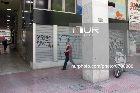 A man seen walking past a closed store at the center of Athens, Greece on May 12, 2021. 