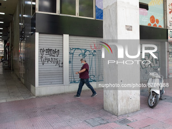 A man seen walking past a closed store at the center of Athens, Greece on May 12, 2021. (