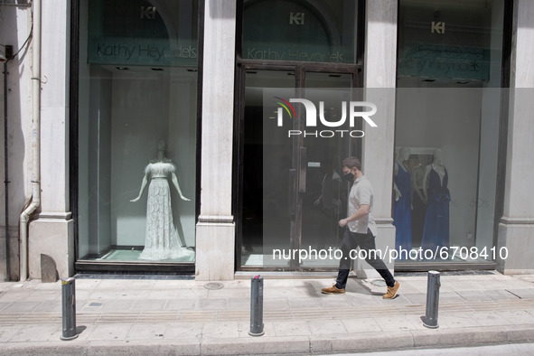 A man seen walking past a closed store at the center of Athens, Greece on May 12, 2021. 