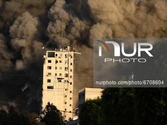 Smoke and flames rise from a tower building as it is destroyed by Israeli air strikes amid a flare-up of Israeli-Palestinian violence, in Ga...