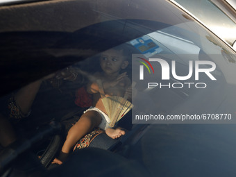 A Children seen into a car with rush to board a ferry at Mawa Ferry Terminal to get home to celebrate Eid al-Fitr, after the government impo...