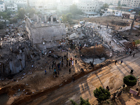 Palestinians inspect the ruins of buildings which were destroyed in Israeli air strikes amid a flare-up of Israeli-Palestinian violence, in...