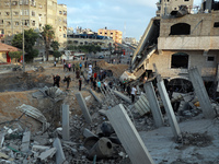 Palestinians gather at the site where buildings and houses were hit in Israeli air strikes amid a flare-up of Israeli-Palestinian violence,...
