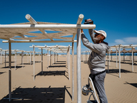 A worker prepares the gazebo on the beach of Margherita di Savoia, Italy  on May 14, 2021.
The managers of bathing beaches have already don...