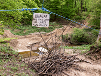 A sign 'Do not cut the rope or a man will die' hangs over a path newly dug by woodcutters, the rope holds a tand with a person inside on May...