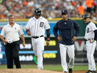 Detroit Tigers Miguel Cabrera walks off the field flanked by Manager Brad Ausmus and Trainer Kevin Rand as the first base coach Omar Vizquel...