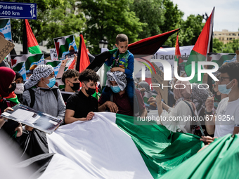 A child on the shoulders of his father holds a Palestinian flag while protesters sing songs of support for Palestine and against Israel in M...