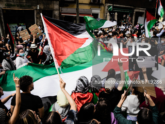 Protesters hold a Palestinian flag as they sing songs of support for Palestine and against Israel in Madrid, Spain, on May 15, 2021, on the...