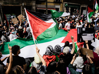Protesters hold a Palestinian flag as they sing songs of support for Palestine and against Israel in Madrid, Spain, on May 15, 2021, on the...