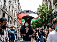 One on her shoulders holds a Palestinian flag as protesters sing songs of support for Palestine and against Israel in Madrid, Spain, on May...