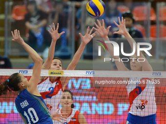 Gabriela Braga Guimaraes (#10) of Brazil spikes the ball as Marta Drpa (#2) and Mina Popovic (#5) of Serbia attemp to block during their FIV...