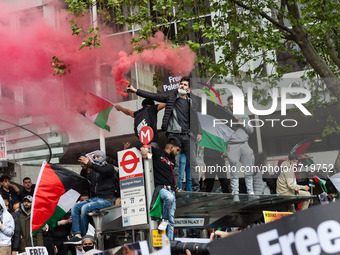 LONDON, UNITED KINGDOM - MAY 15, 2021: Demonstratore set off the flares as thousands of people gather outside the Israeli Embassy after marc...