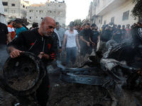 Palestinians inspect the wreckage of a car after it was hit by an Israeli missile strike in Gaza City Saturday, May 15, 2021.
 (