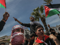 A demonstrator on top of a protester's shoulders, gestures and shouts anti-Israel slogans as other demonstrators wave flags of Palestine dur...