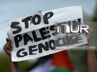 A Pro-Palestinian protester holds a placard with worlds 'Stop Palestinian Genocide'  next to the Israeli Embassy on Pembroke Road in Dublin...