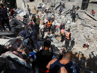 Palestinian paramedics search for survivors under the rubble of a destroyed building in Gaza City on May 16, 2021, following massive Israeli...