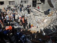Palestinian paramedics search for survivors under the rubble of a destroyed building in Gaza City on May 16, 2021, following massive Israeli...