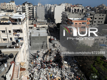 Palestinian rescue teams search for survivors under the rubble of a destroyed building in Gaza City's Rimal residential district on May 16,...