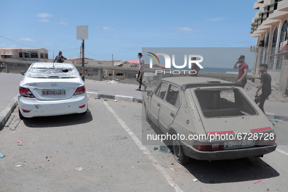 Palestinians inspect a civilian car that has been bombed by an Israeli bomb near the Gaza Sea, Gaza City, May 17, 2021