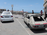 Palestinians inspect a civilian car that has been bombed by an Israeli bomb near the Gaza Sea, Gaza City, May 17, 2021(