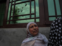 Kashmiri women stand outside the damaged residential house after encounter between Indian Forces and Alledged militants was over in Khonmuh...