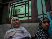 Kashmiri women stand outside the damaged residential house after encounter between Indian Forces and Alledged militants was over in Khonmuh...