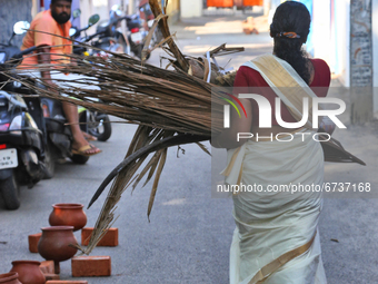 Hindu woman carries a bundle of dried coconut flower sheaths (kothumbu) to be used as fuel for a fire when cooking pongala during the Attuka...