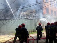 Firefighters try to extinguish a fire in a high-rise building at Kakrail in Dhaka, Bangladesh, on May 21, 2021. According to fire services,...