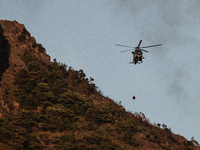 A Government flying service helicoper flies dangerously close to the flanks of Kowloon Peak during a rescue mission in Hong Kong, China, on...