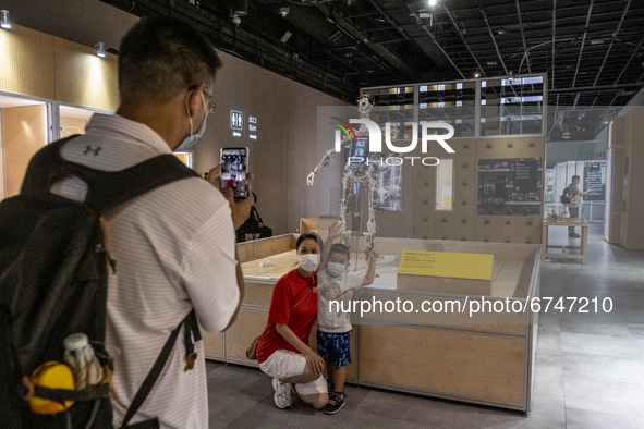 A Visitor takes a photo with an exhibition item at the “Robots, The 500-Year Quest to Make Machines Human