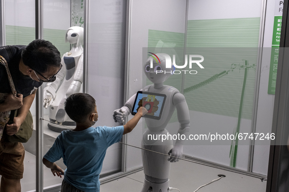 Visitors interacting with a Robot on display at the “Robots, The 500-Year Quest to Make Machines Human