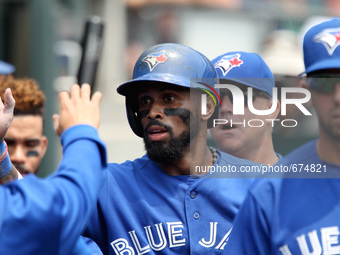 Toronto Blue Jays' Jose Reyes is congratulated by teammates after scoring a run on a single hit by Josh Donaldson in the first inning of a b...