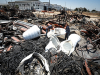 Palestinian worker salvage items at a damaged plastic pipes factory in Gaza's industrial area, on May 25, 2021, which was hit by Israeli str...