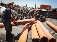 Palestinian worker salvage items at a damaged plastic pipes factory in Gaza's industrial area, on May 25, 2021, which was hit by Israeli str...