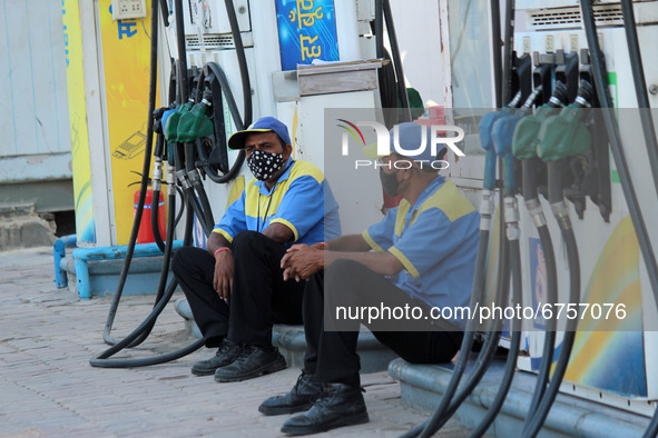 A fuel station attendant waits for customers at a petrol station in New Delhi, India on May 26, 2021. In Delhi, petrol rates climbed to ₹93....