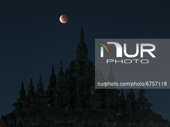Super Blood Moon are seen above an ancient Plaosan Buddhist temple complex, Central Java, on May 26, 2021. The Super Blood Moon occurs when...